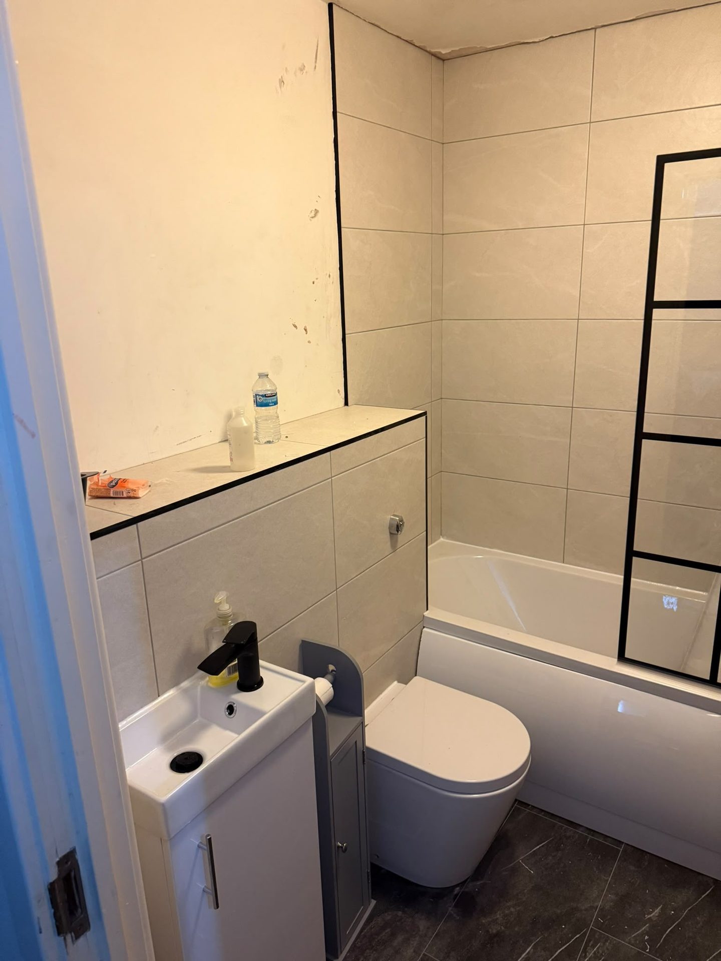 Compact bathroom installation with vanity unit and marble-effect tiling