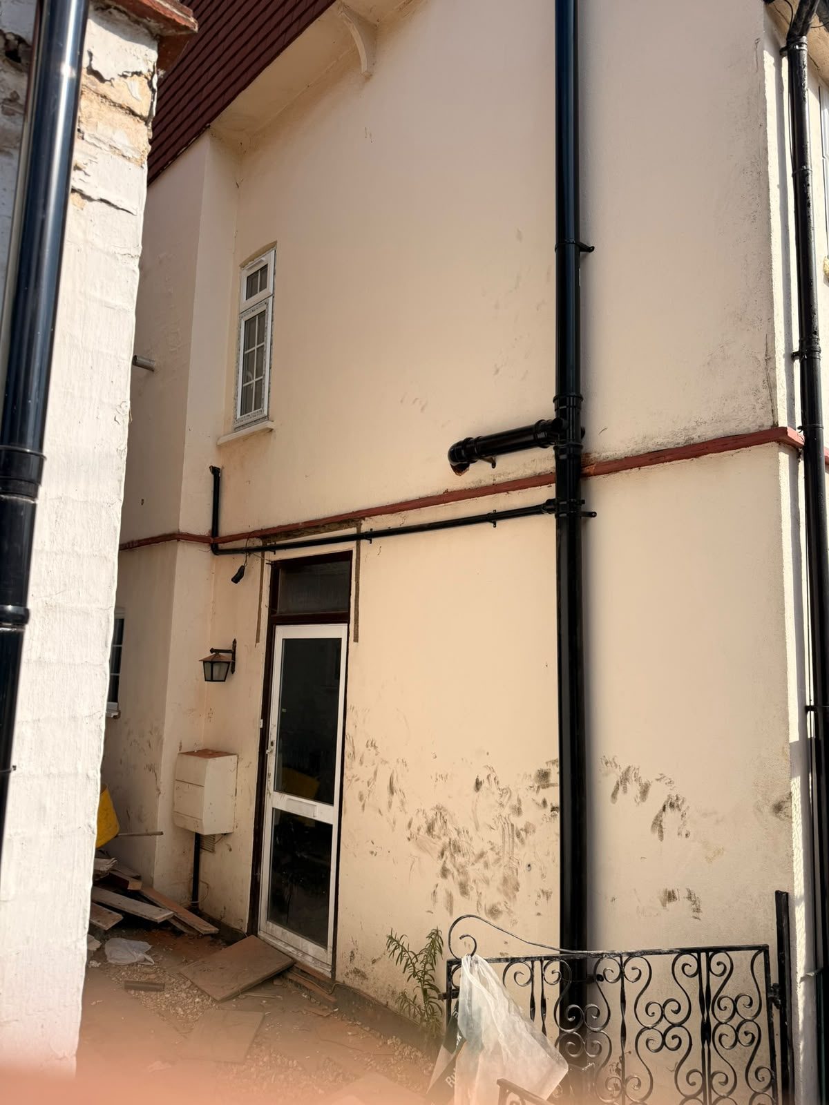 New external black waste and soil pipework installed on the outside wall of a house