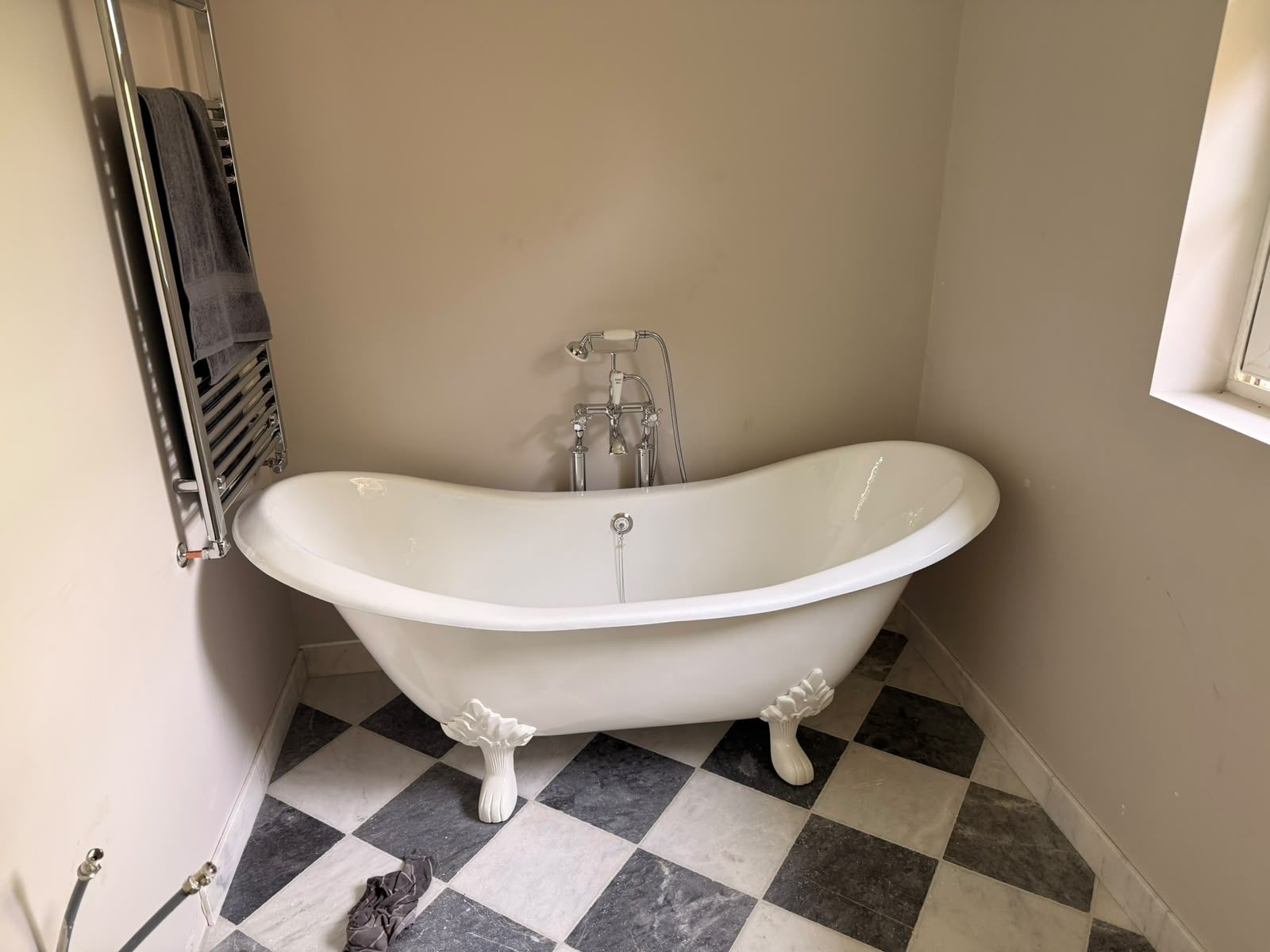 Freestanding roll-top bath plumbed in above chequerboard floor tiles on a completed JY Plumbing & Heating bathroom job