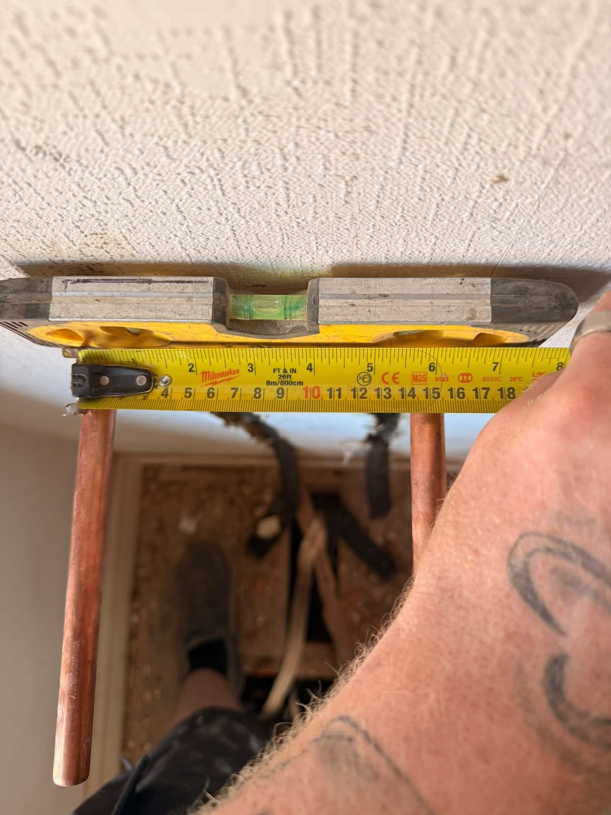 Copper pipework being set out and levelled with a spirit level during a plumbing installation