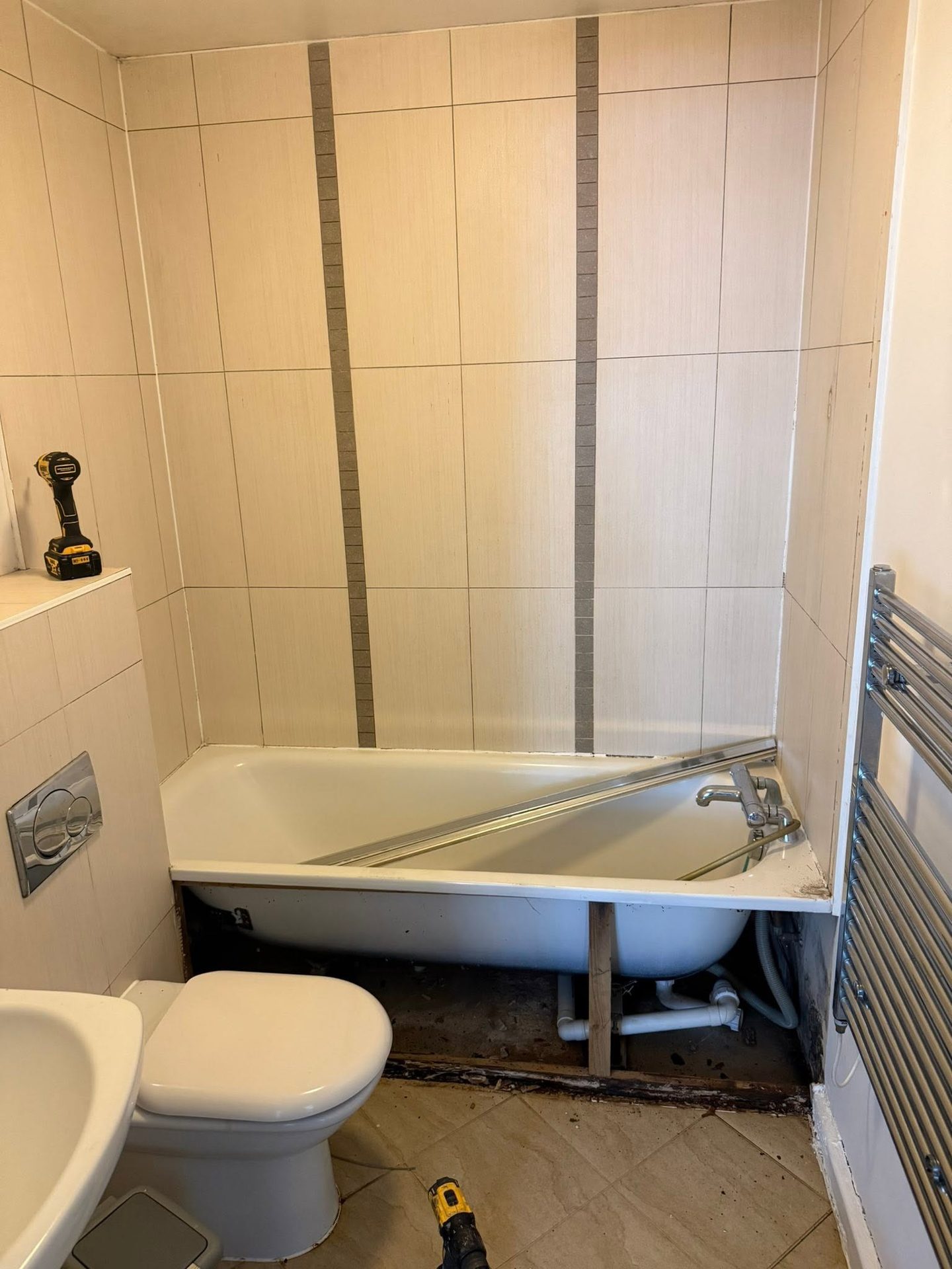 Tired High Wycombe bathroom before renovation, with the old bath panel removed and dated tiling in place